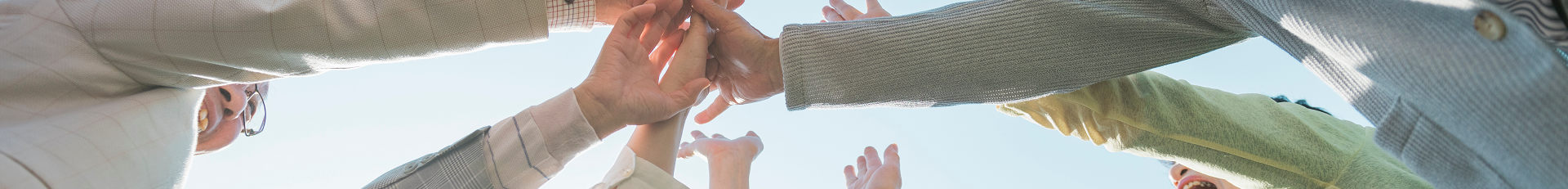 People Joining Hands in a Huddle